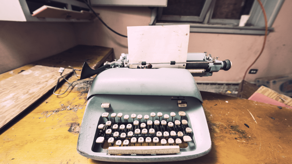 antique typewriter with empty page because of writer's block