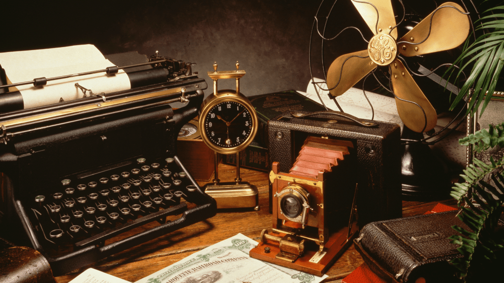 a vignette of antique items including a camera, clock, and typewriter