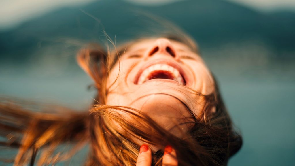 woman with head back and mouth open in delight