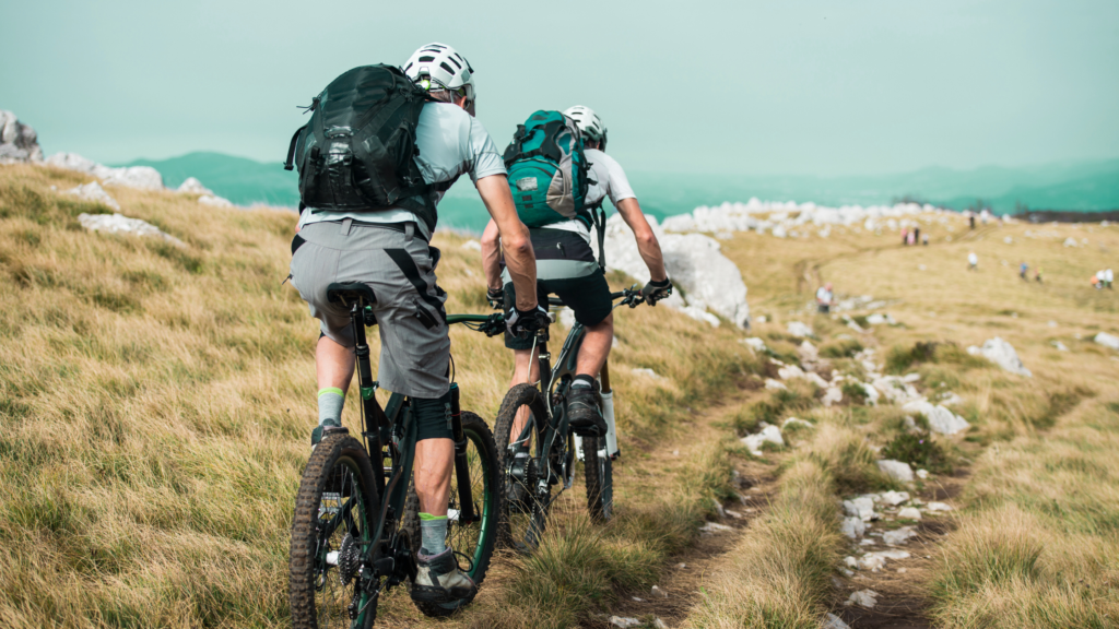 two mountain bikers riding up a steep mountain trail