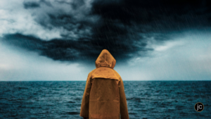 A person in a yellow rain coat facing a menacing storm