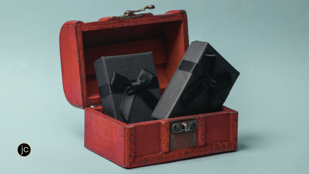 A red wooden treasure chest with wrapped presents inside, tied with bows, to signify a key to how to find joy in writing