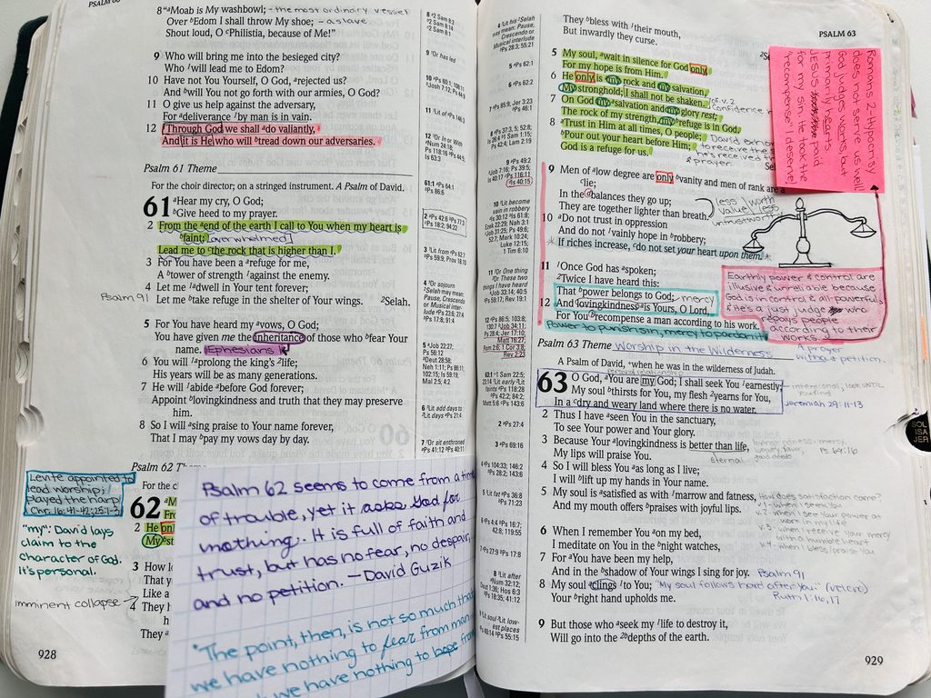 An open Bible with some verses highlighted in different colors, handwritten notes in the margins, and sticky notes with additional notes