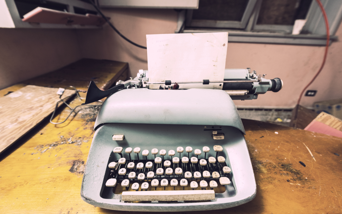 antique typewriter with empty page because of writer's block