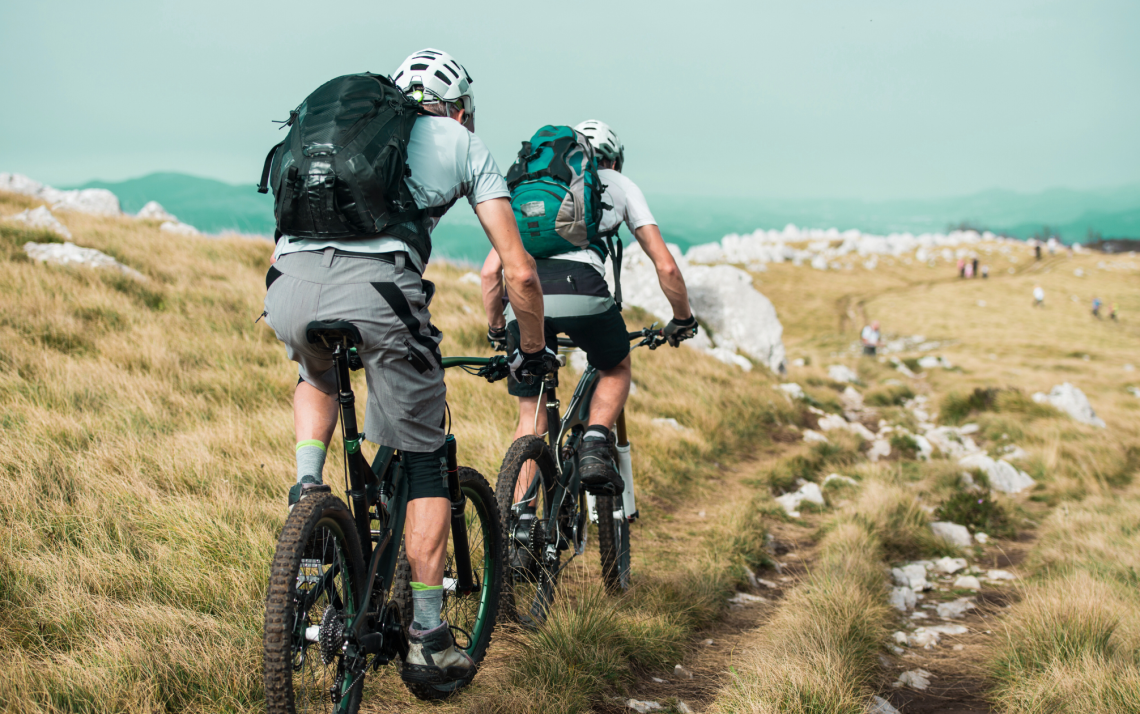 two mountain bikers riding up a steep mountain trail